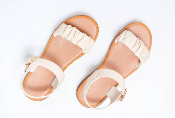 istock Female beige sandals on a white background close-up top view. 1396615073