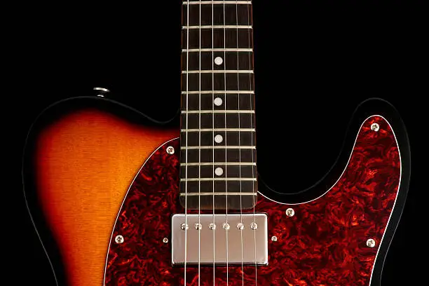 Electric guitar with a sunburst finish and tortoise pickguard.  Black background for darker designs.