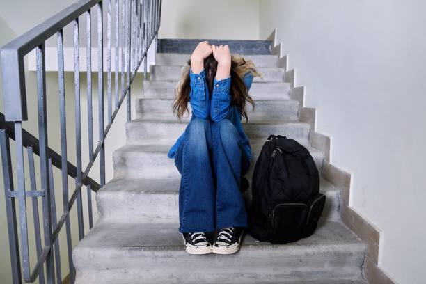 Sad frustrated young woman sitting on the steps stock photo