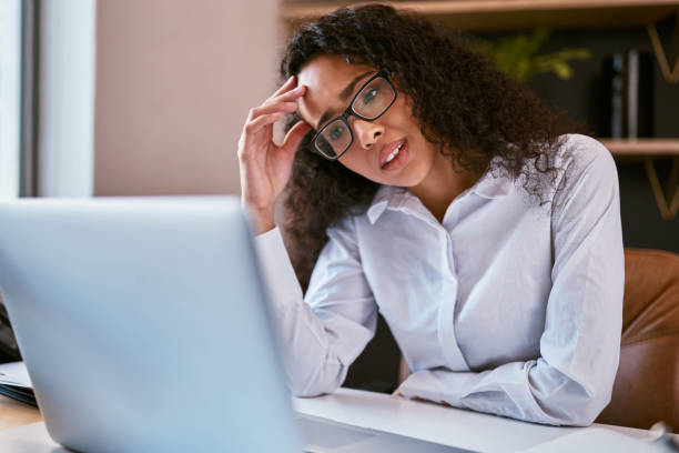 istock Young mixed race business woman feeling stressed while browsing the internet on a laptop in the office. Confused hispanic entrepreneur struggling while using a computer to work on her startup business 1396617299