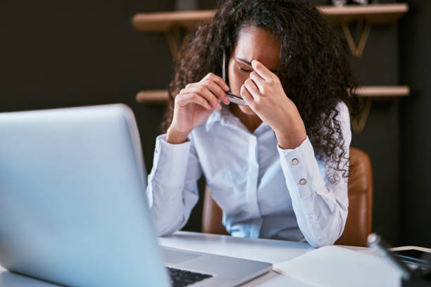 istock Young mixed race business woman feeling stressed and suffering from a headache while working on a startup in an office. Confused hispanic entrepreneur in pain with a migraine using a laptop to work 1396617323