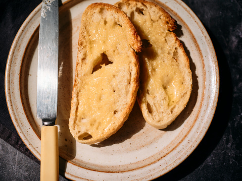 overhead view of two sliced of San Francisco style sourdough bread toasted spread with melted butter.