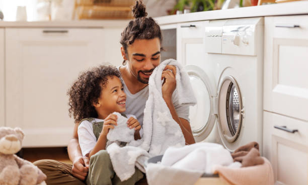 istock Son helping dad to load washing machine 1396618576