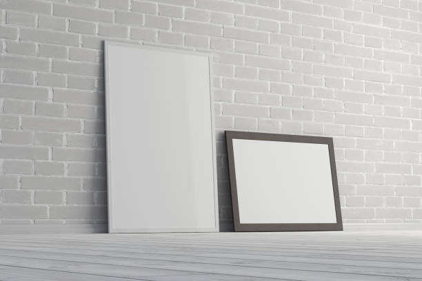 istock Mock up of horizontal and vertical black and white frames on the floor with white brick wall. 1396622269