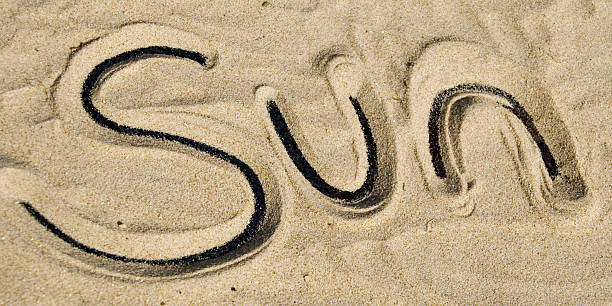 Sun, writing in sand stock photo
