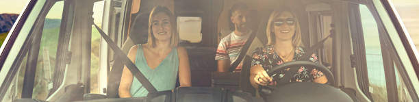 istock Front view through windshield of friends traveling in camper van 1396622529