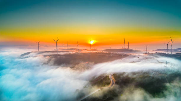 Aerial view top hill at dawn with fog covering small village in valley stock photo