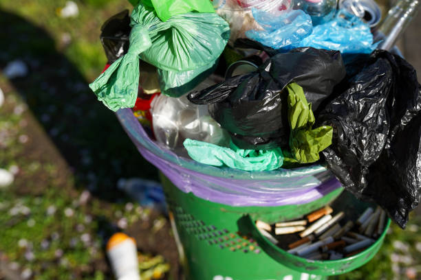 istock Full over capacity dust green bin on town street 1396624425
