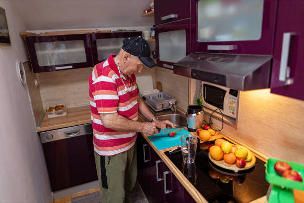 portrait of a mature man preparing fruit smoothie - blender apple banana color image imagens e fotografias de stock