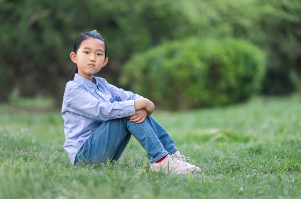 istock Little Girl Sitting on Lawn 1396625620