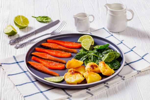 fette di salmone con foglie di spinaci, patate arrosto - smoked salmon salt healthy lifestyle cold foto e immagini stock