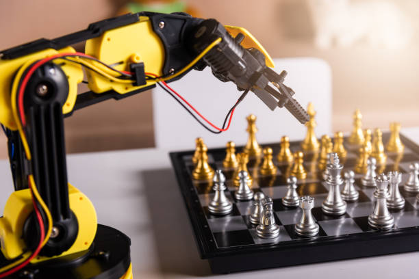 istock Closeup yellow robot arm playing move chess on chessboard 1396627764