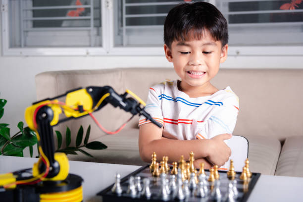 istock Asian little boy is playing chess with robot machine arm 1396627777