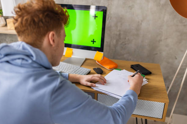 istock Caucasian redhead teenage boy doing homework 1396630130