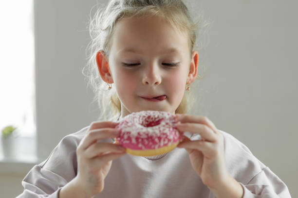 istock Girl eating unhealthy donut 1396630145