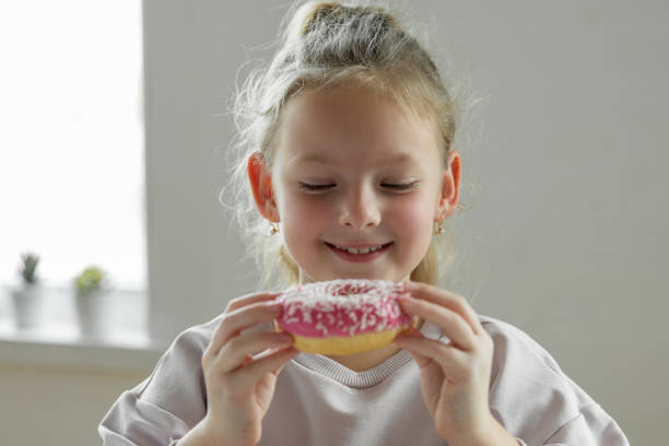 istock Girl eating unhealthy donut 1396630196