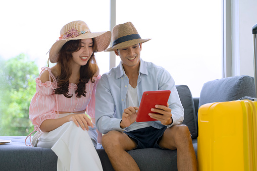 Young couple is preparing for travel.They are chenking information on internet and prepare documents. Travel concept.