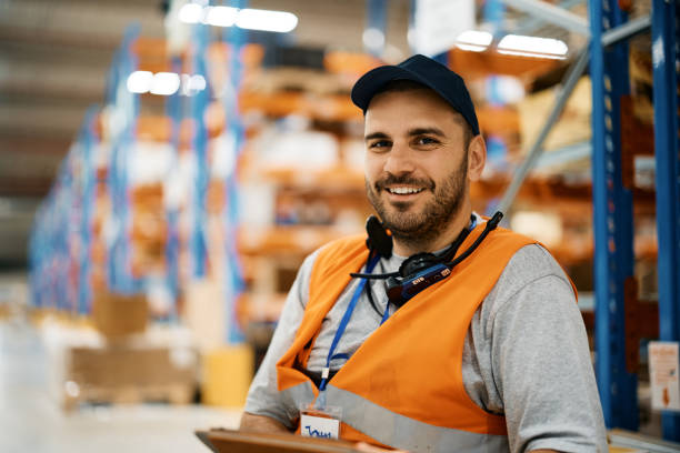 feliz trabajador de almacén trabajando en el compartimento de almacenamiento y mirando la cámara. - compartimento para almacenamiento fotografías e imágenes de stock