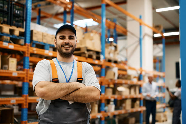 istock Happy warehouse worker standing with arms crossed and looking at camera. 1396633135