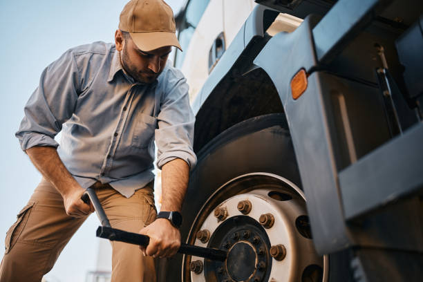 istock Truck driver changing flat tire on his truck. 1396633171