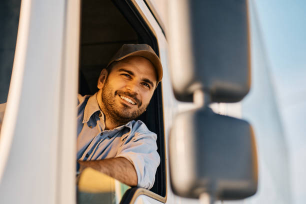 istock Happy truck driver looking through window from the vehicle cabin. 1396633270