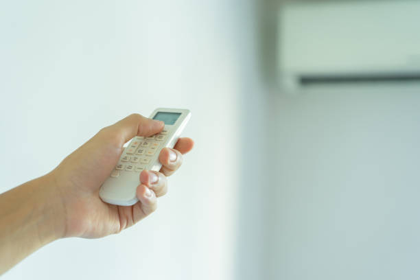 istock close up human hand holding remote control to turn on air conditioner at inside home for savings energy , sustainable lifestyle concept 1396636257