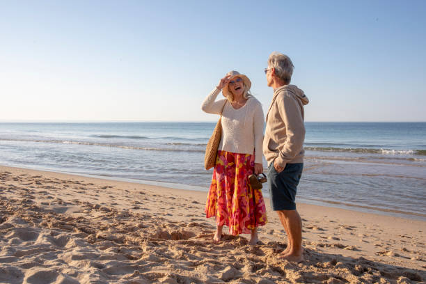istock Mature couple relax on sandy beach, at sunrise 1396636595