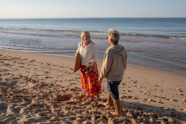 Mature couple relax on sandy beach, at sunrise