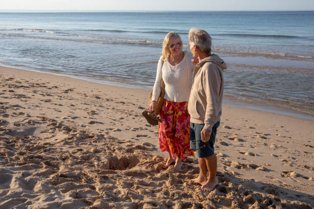 istock Mature couple relax on sandy beach, at sunrise 1396637289