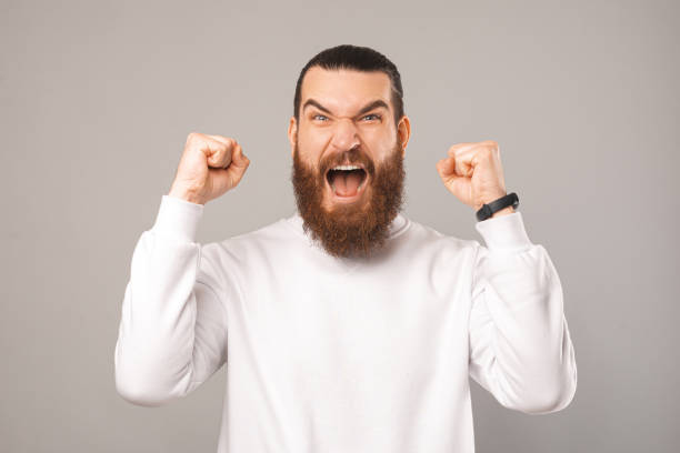 istock Powerful bearded man is screaming and making the winner gesture. 1396637900