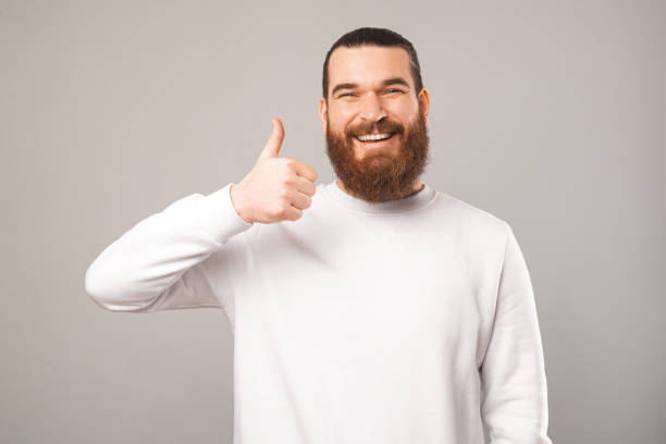 istock Friendly bearded man is showing thumb up while smiling at the camera. 1396637908