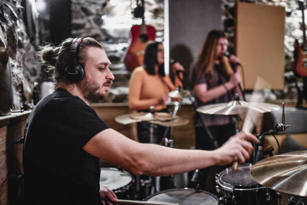 istock Bearded Drummer Shows The Speed Of The Drum In The Studio While Practicing With The Band 1396642409