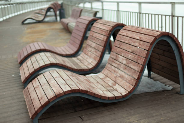 istock Benches for recreation in park. Comfortable seating. Sun beds on waterfront. 1396643091