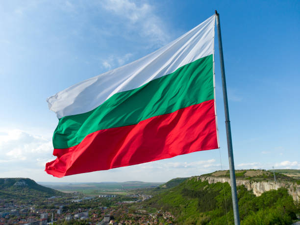 Bulgaria National Flag Waving on pole against sunny blue sky background stock photo