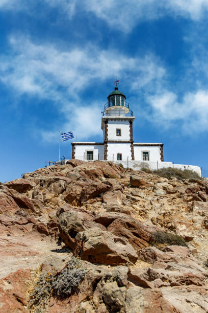 istock The old lighthouse on the rocky sea coast. Blue sky with clouds. 1396644419