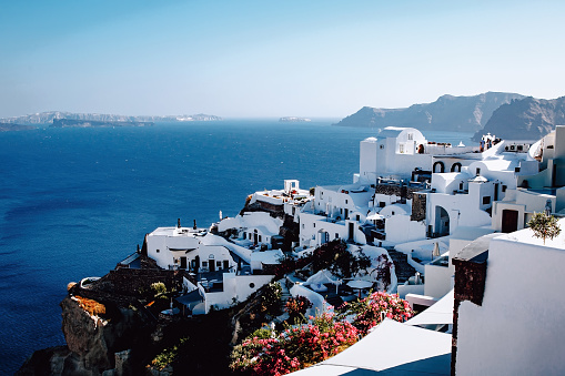 Traditional greek white houses on Santorini coast near the Aegean Sea. Village on the cliff under blue sky