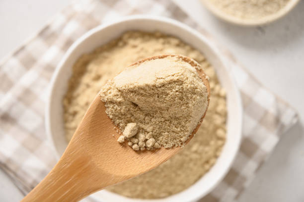 istock Sesame flour in wooden spoon on white. 1396645839