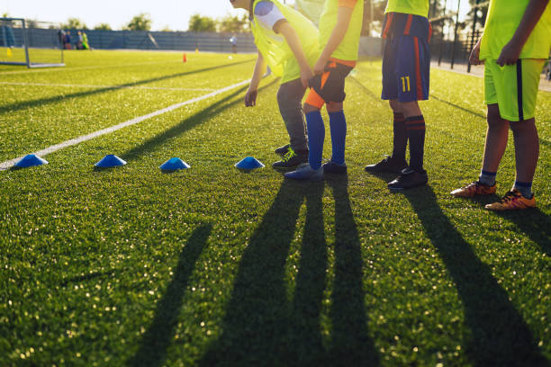 school kids standing in a row at physical education training session. happy children play sports on sunny summer day - soccer ball youth soccer event soccer imagens e fotografias de stock