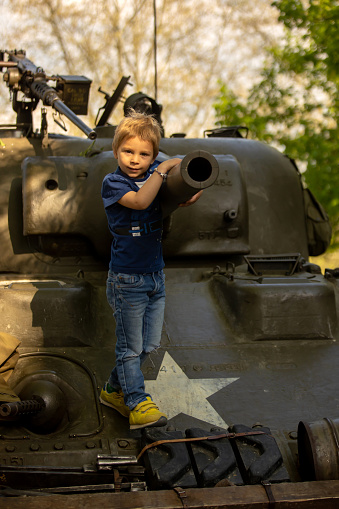 Kiev / Ukraine - June 1, 2019: father takes photo of son in military tank in Kiev military museum