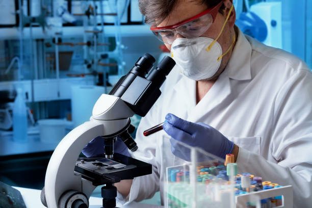 Scientist Researcher working with blood test tube and microscope in biotechnology lab doctor holding Blood tube of patient for analysis to microscope in the microbiology laboratory. Scientist Researcher working with blood test tube and microscope in biotechnology lab human centrifuge stock pictures, royalty-free photos & images