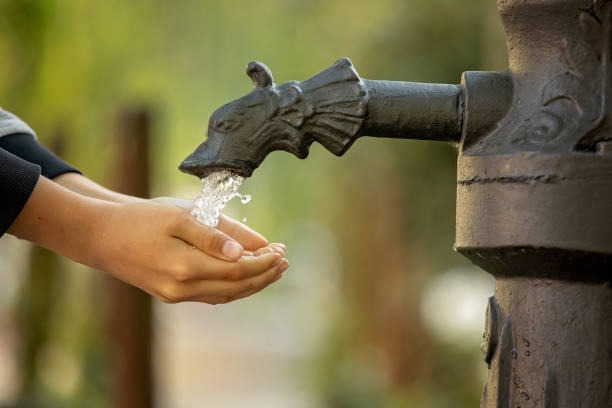 istock Boy washes his hand under the faucet in park 1396648456