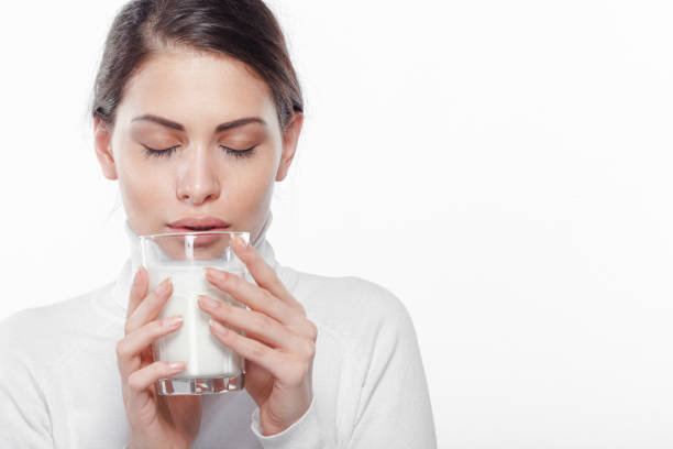 Beautiful young woman holding a glass of milk stock photo