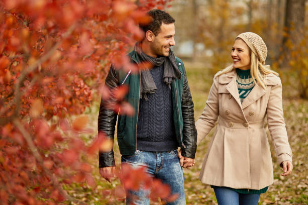 istock Young couple taking a walk in autumn park holding hands 1396653869