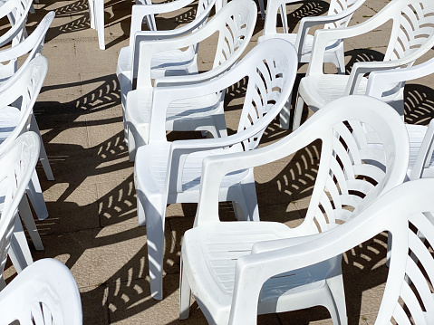 Photographs of white plastic chairs placed outside and the shadow reflected on the floor