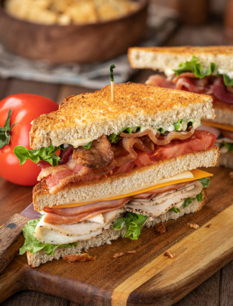 club sandwich a base di pancetta prosciutto di tacchino lattuga e pomodoro - sandwich turkey cold cuts snack foto e immagini stock