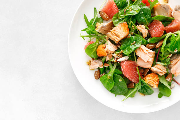 istock Grilled salmon salad with grapefruit, almonds and salad mix. Top view 1396661094