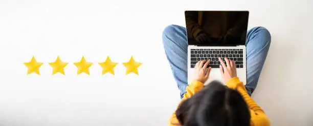 Photo of Customer experience concept. Top View of woman sitting on the floor and using computer laptop