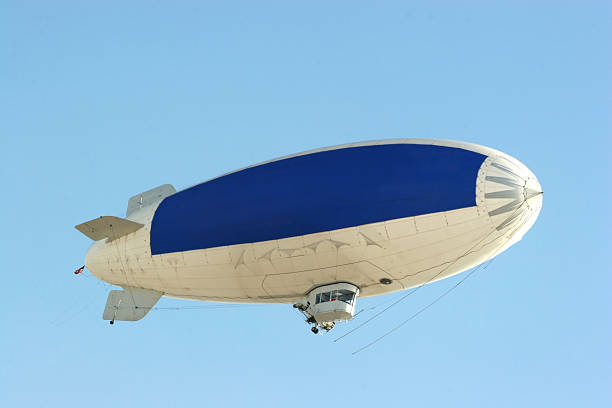 blue copy space on blimp to advertise your message blimp flying in clear blue sky with blue copy space to advertise your message blimp stock pictures, royalty-free photos & images