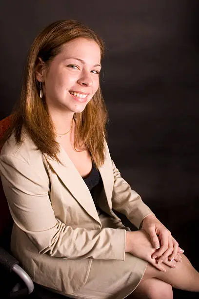 Businesswoman in chair, smiling at the camera(you).