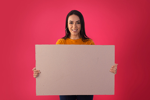 Young woman holds advertising boards with facial expressions.